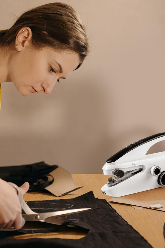 Woman cutting fabric with a sewing machine on a table
