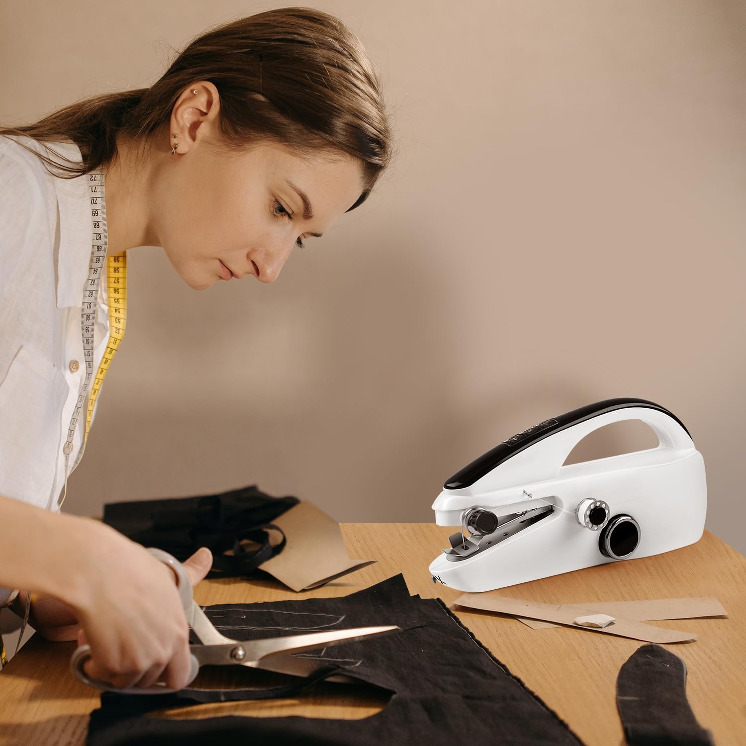 Woman cutting fabric with a sewing machine on a table